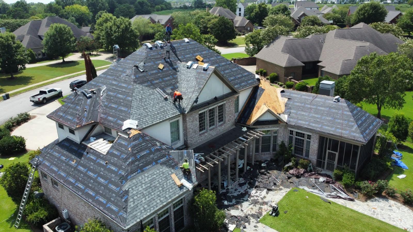 Residential roof replacement — crew at work mid-install